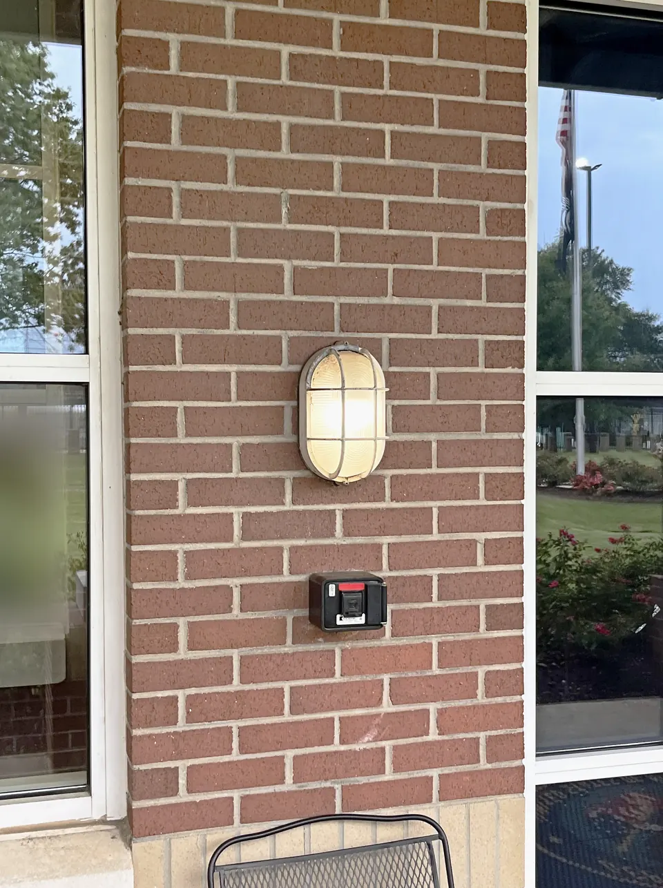 Before: old caged bulkhead light fixture on the brick wall