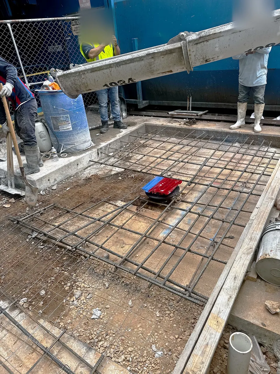 Concrete being placed into the formed and reinforced pad