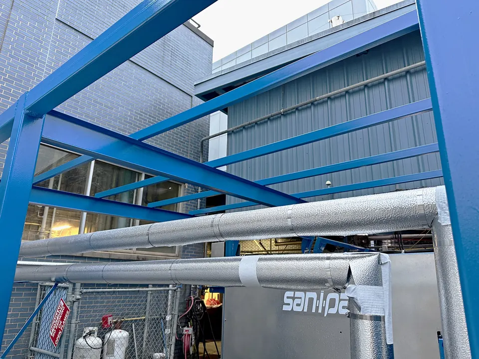 Steel canopy painted blue, with insulated piping below