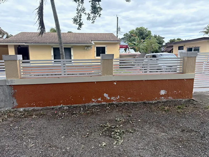 The same home before the work: faded yellow paint and a peeling orange front wall