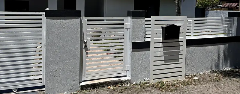 Front wall after: stucco repaired and refinished in gray with a dark cap